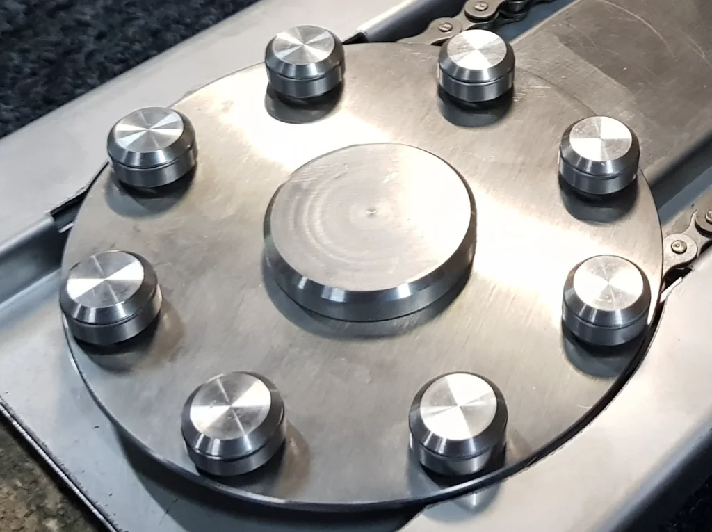 Precision stainless steel rotary component and chain assembly demonstrating industrial engineering solutions.